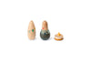 The image shows three wooden toys. On the left, there is an egg-shaped figure with a simple design, featuring a string of green and yellow triangular flags painted around its middle. In the center, there is another egg-shaped toy with a more detailed design, resembling a person with a painted face and clothing. On the right, there is a small spinning top with a conical tip and a circular base, decorated with small colored dots.