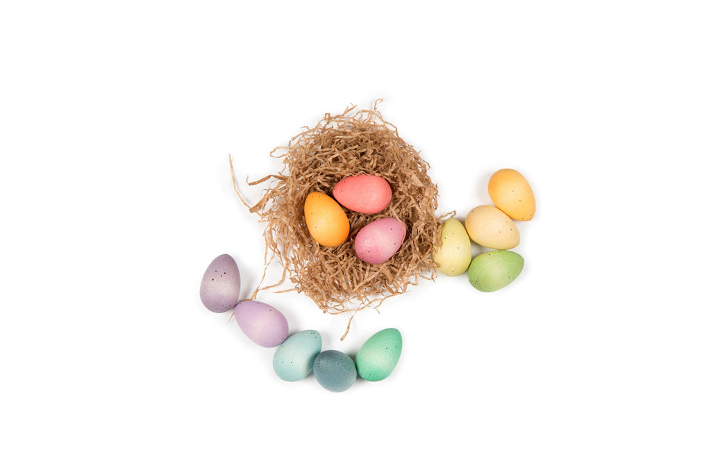A box of colorful painted wooden eggs on a plaid tablecloth.
