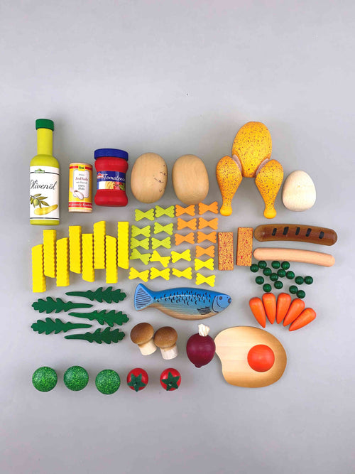 Woodberry Erzi Assorted Cooking Enjoyment for Play Kitchen Food Wooden Toy Set Top view. Including (top row) a bottle of olive oil, a can of beans, pasta sauce, 2 potatoes, a roast chicken, an white egg, (second row) 8 french fries, 21 bow tie pastas, 2 fish sticks, a sausage, a hotdog., some peas, (third row) 5 arugula, 1 herring, 5 baby carrots, 2 cremini mushrooms, a beet, a sunny side up egg, ( bottom row) 3 broccoli, 2 cherry tomatoes.