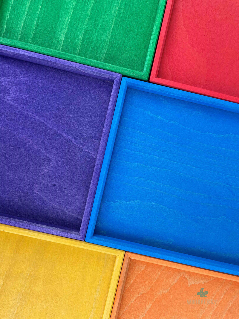 Woodberry Bauspiel set of 6 rainbow color trays arranged adjacent to each other and up close to show texture of trays. 