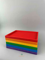 Woodberry Bauspiel set of 6 rainbow color trays stacked on top of each other. 