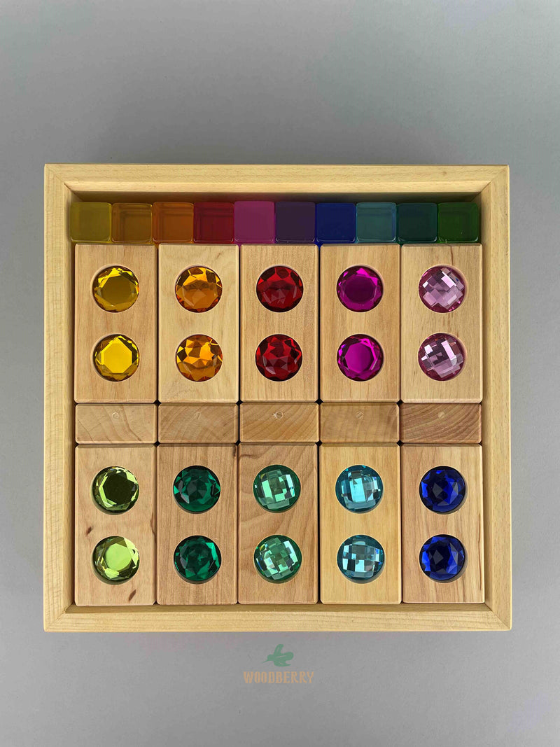 Top-down image of Bauspiel combination set complete in tray. Includes 20 wooden colour street blocks, 20 acrylic lucent cubes, and 5 gemmed window blocks. 