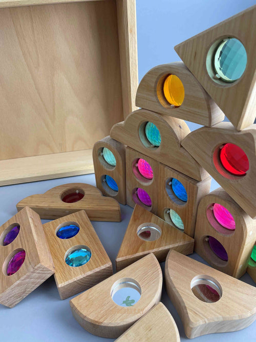 Image of Bauspiel Fairy Tale block combination set. Tray is upright, with small stack of random gemmed and mirror blocks displayed in the front with several blocks laying flat on the surface. 