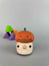 Halloween wooden toy. Mushroom Ramp walker with a orange pumpkin Jack'O'Lantern hat with purple, green and orange wooden building blocks in the background