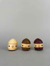 Three wooden acorn toy with eyes and mouths standing side by side. Wooden acorn toys ramp walker Teak, Shina and Purple Heart from Japan. Special limited edition Natural wood 