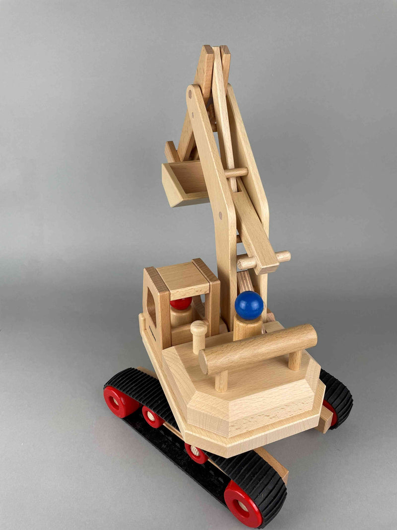 Woodberry Fagus Excavator wooden toy rear angle view with raised arm and bucket. Shows vehicle tread. 