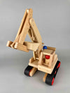 Woodberry Fagus Excavator wooden toy front angle view with raised boom and bucket. Includes two peg people. 