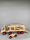 Woodberry Fagus Car Transporter shown with bed lowered. Two peg people sit in the truck and a racer car. 
