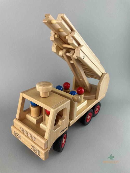 Fagus Wooden Fire truck with six peg dolls. The fire truck has lifted arm in the back. Photo is taken at an 45 degree upper angle from the front