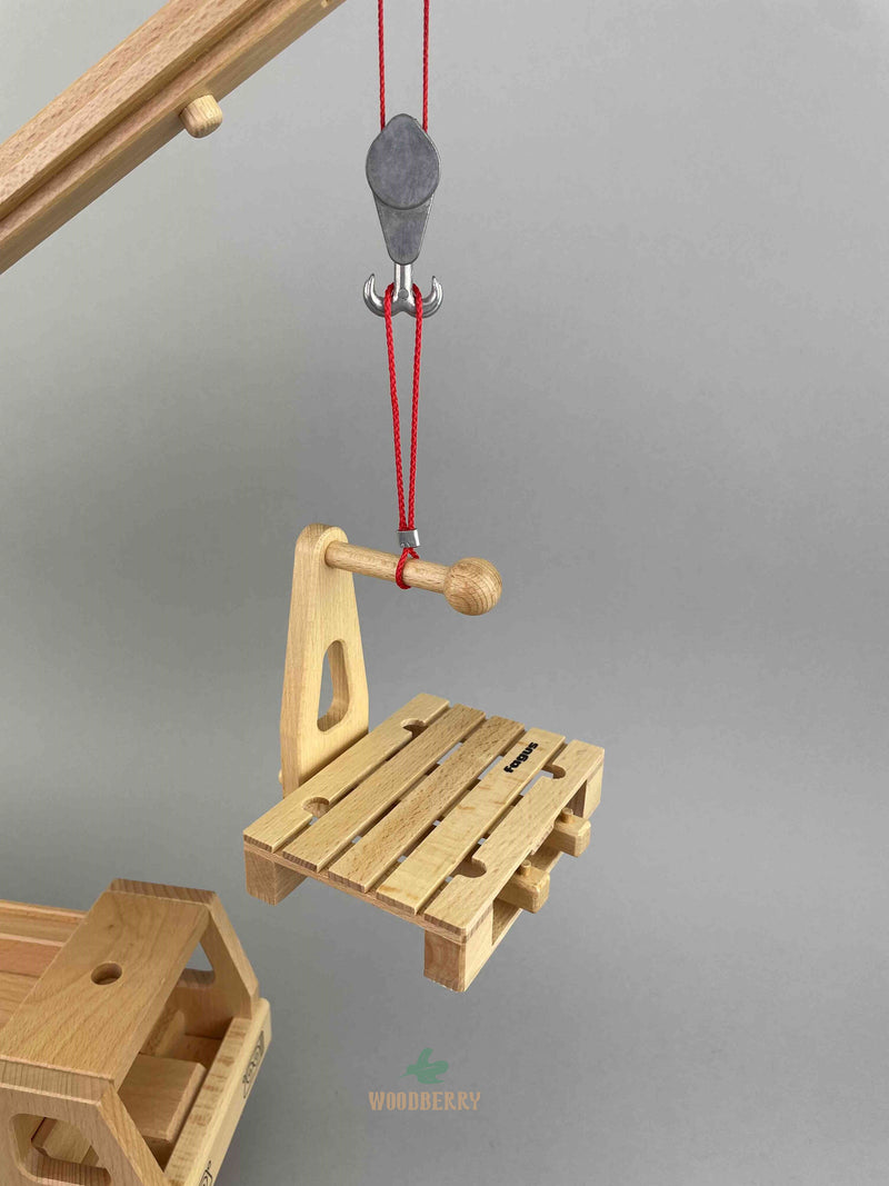 Wooden Fork attachment for the Fagus mobile crane or floor crane. A close-up of the fork attachment attached with the euro pallet on the double hook of the wooden mobile crane by Fagus toys
