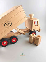 Woodberry Fagus Garbage Truck wooden toy side angle view of truck with raise truck bed for dumping contents. Two Fagus garbage bins sit in the foreground.