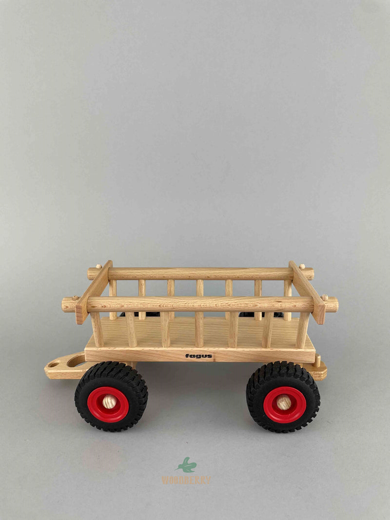 The side view of the Fagus Hay wagon wooden toy. Can see the front and back hitch.