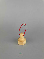A wooden lifting magnet with red loop hanging rope by Fagus toy. 