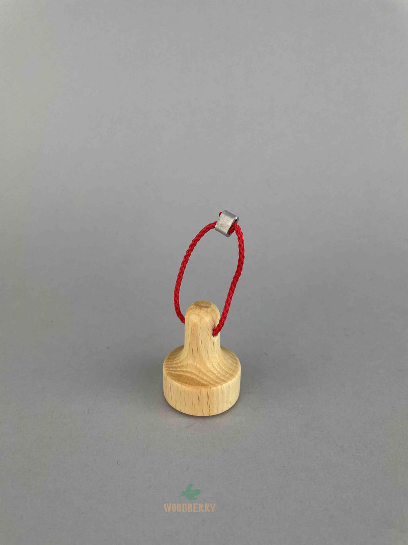A wooden lifting magnet with red loop hanging rope by Fagus toy. 