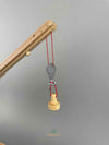 A wooden lifting magnet with red loop hanging rope by Fagus toy. The lifting magnet is attached on the double hook of the Fagus mobile crane's extended arm