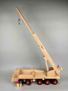 Woodberry Fagus Mobile Tower Crane wooden toy with raised and fully extended arm to show full height. Includes two peg people in the foreground. 