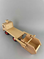 Woodberry Fagus Skip Truck with arm extended and cargo on the ground behind the truck bed.