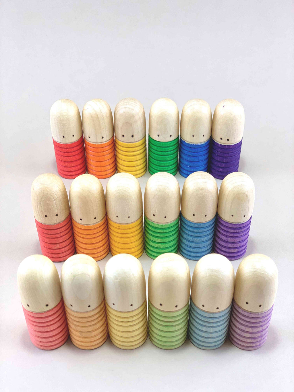 Set of 18 Grapat Brots wooden figures in six color groups, arranged in two rows on a neutral background