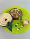 Woodberry Oak Village marble run tree stump with glass marbles and wooden squirrel figure on green felt mat. Tree stump cover is opened to reveal inside.