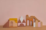 Raduga Grez Apartment Building blocks displayed in front of a pink background and tanned floor