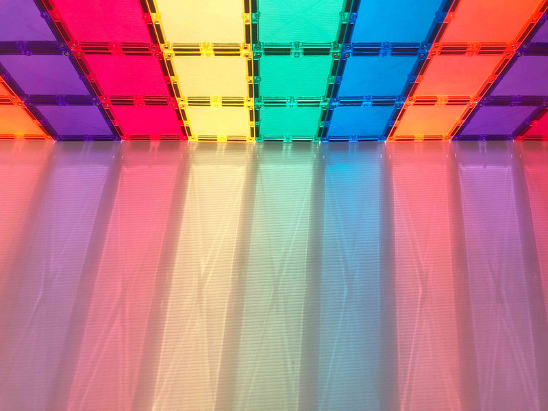 Light shines through the magnetic tiles by Connetix forming rainbow color shadows on the surface