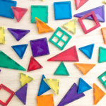 Random connetix tiles scattered on the floor. Including the right triangle, isosceles triangles, equilateral triangles, square and windows 